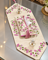Zareen hand embroidered ivory floral table runner and matching tissue box cover set with pink flowers, green leaves and tassel detailing