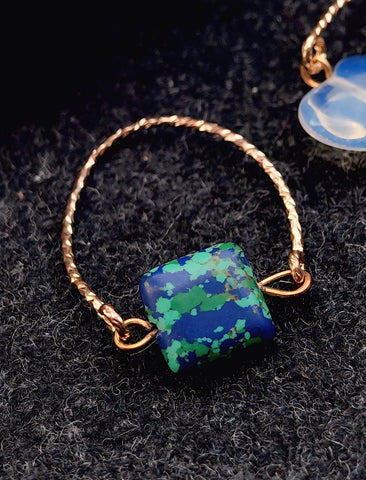 Bracelet with a blue and green square stone on a dark textured background