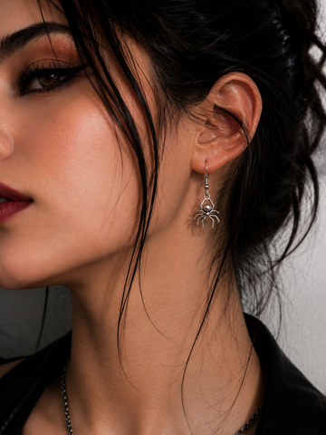 Midnight Grunge 5-Pair Silver Gothic Earring Set on a marble tray, featuring textured snake hoops, sword dangles, skull butterflies, spiders, and witch knot earrings by Marjan Collections