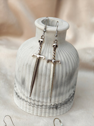 Midnight Grunge 5-Pair Silver Gothic Earring Set on a marble tray, featuring textured snake hoops, sword dangles, skull butterflies, spiders, and witch knot earrings by Marjan Collections