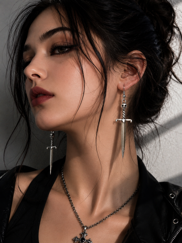 Midnight Grunge 5-Pair Silver Gothic Earring Set on a marble tray, featuring textured snake hoops, sword dangles, skull butterflies, spiders, and witch knot earrings by Marjan Collections