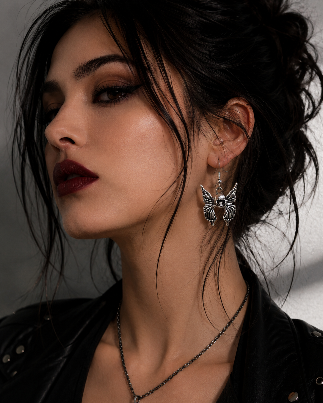 Midnight Grunge 5-Pair Silver Gothic Earring Set on a marble tray, featuring textured snake hoops, sword dangles, skull butterflies, spiders, and witch knot earrings by Marjan Collections