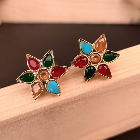 Colorful flower-shaped earrings on a wooden surface