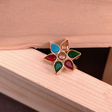 Colorful flower-shaped earring on a wooden surface